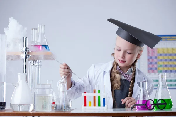 Schattig schoolmeisje werkt met chemicaliën in laboratorium — Stockfoto