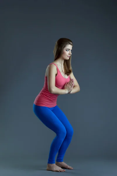 Aantrekkelijke yoga trainer toont asana in studio — Stockfoto