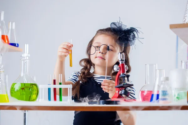 Lustiges Mädchen schaut durch ihre Brille auf Röhre — Stockfoto