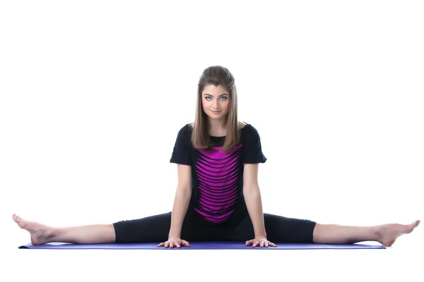 Menina bonita flexível esticada no tapete de ioga — Fotografia de Stock