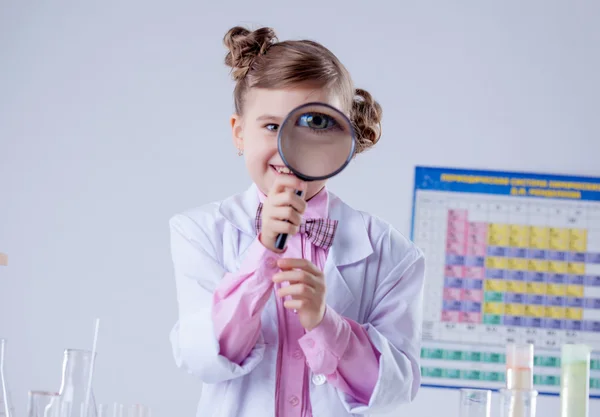 Adorable girl looking through magnifying glass — Stock Photo, Image