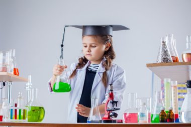 küçük kızı kimya laboratuarında poz konsantre
