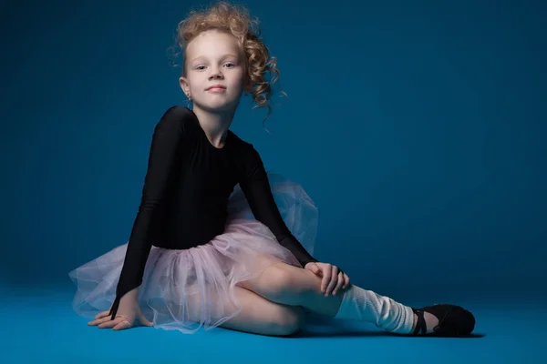 Cute curly ballet dancer posing on blue background — Stock Photo, Image