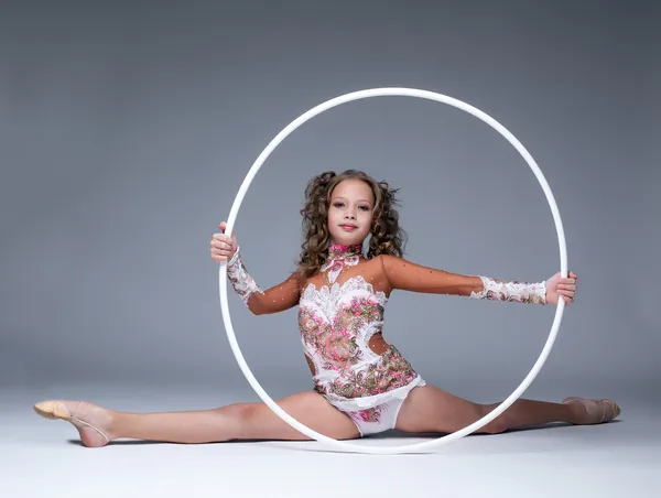 Adorável jovem ginasta artística sentado na divisão — Fotografia de Stock