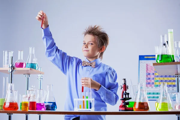Niño lindo posando con variedad de reactivos en el laboratorio —  Fotos de Stock
