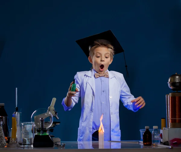 Очень удивлённый мальчик проводит эксперименты в лаборатории — стоковое фото