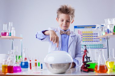 lachende jongen voeren experiment in chemie lab