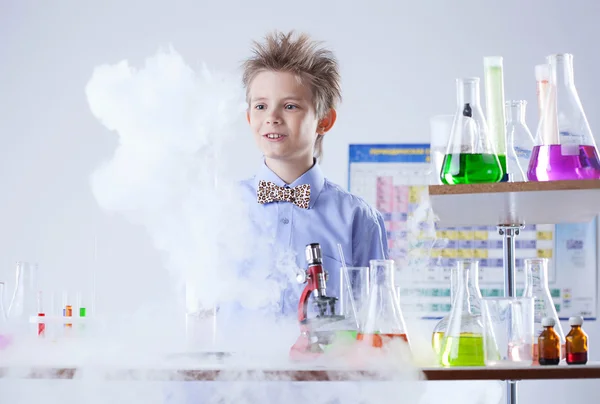 Curious pupil posing with test tubes and flasks — Stock Photo, Image