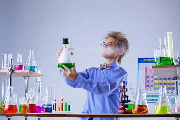 Niño curioso buscando evaporación de reactivo — Foto de Stock