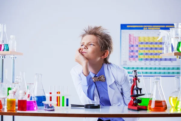 Pensativo lindo chico posando entre el equipo químico — Foto de Stock