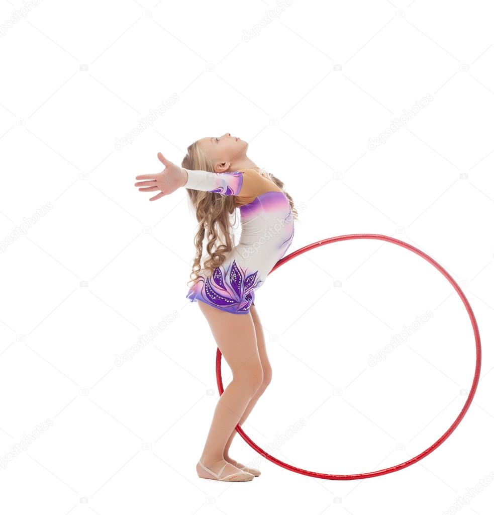 Flexible gymnast dancing with hoop in studio