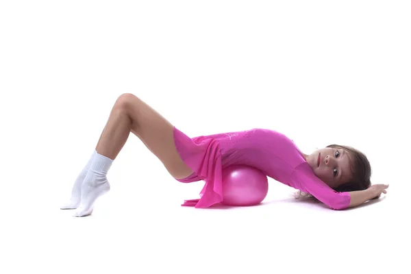 Cute little gymnast posing lying in studio — Stock Photo, Image