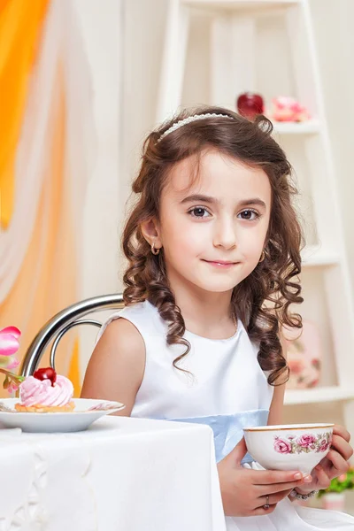 Mooi bruin-eyed meisje het drinken van thee met zoetigheden — Stockfoto