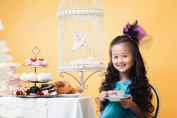 Χαμογελώντας πίνοντας τσάι όμορφη κοπέλα με γλυκό μεταχειρίζεται — Φωτογραφία Αρχείου