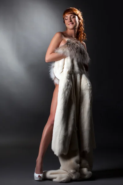 Pretty smiling nude girl posing with fur coat — Stock Photo, Image