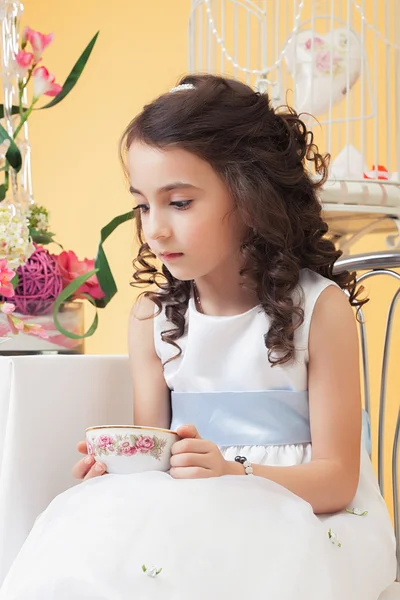 Lovely melancholy little girl drinking tea — Stock Photo, Image