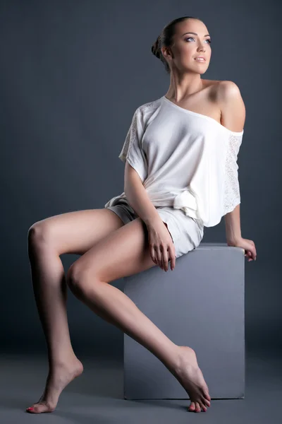 Bild des schönen langbeinigen Mädchens sitzt auf Würfel — Stockfoto