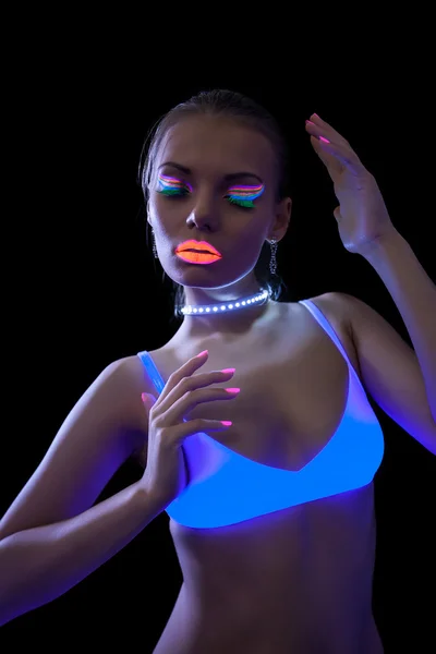 Pretty slim girl dancing under fluorescent light — Stock Photo, Image