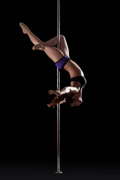 Athletic young pole dancer, isolated on black — Stock Photo, Image