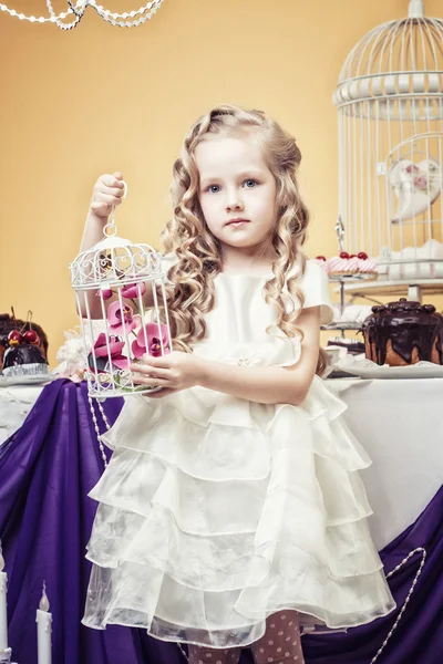 Smart little girl posing in cozy decorated studio — Stock Photo, Image