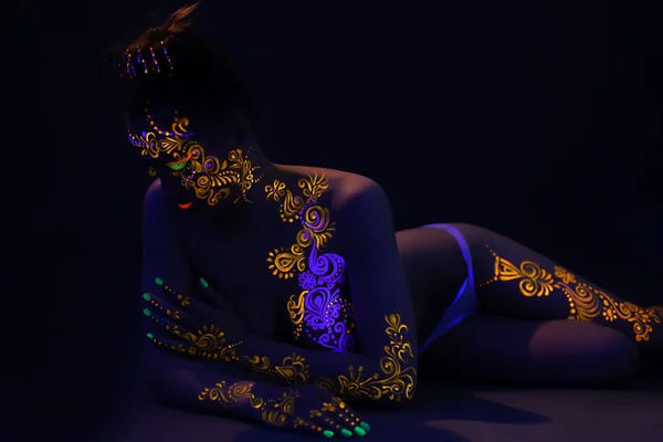 Sensual girl posing nude under ultraviolet light — Stock Photo, Image