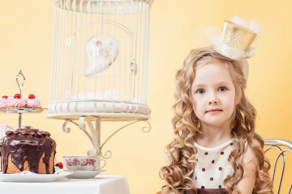 Niedliche kleine Dame posiert am Tisch sitzend — Stockfoto