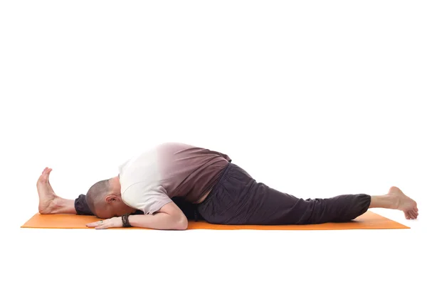 Flexible muscular man in sports wear doing yoga — Stock Photo, Image