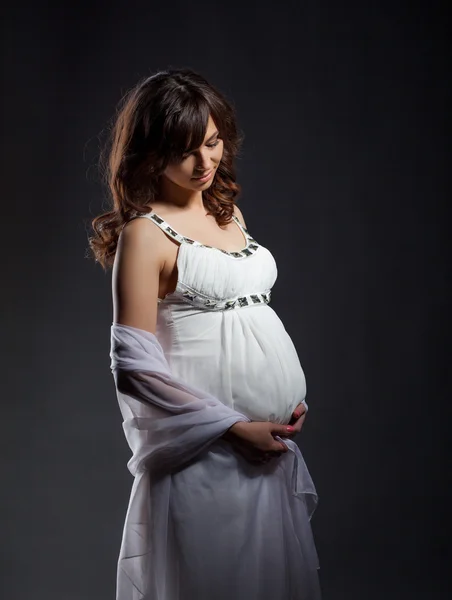 Расслабленная беременная женщина обнимает живот — стоковое фото