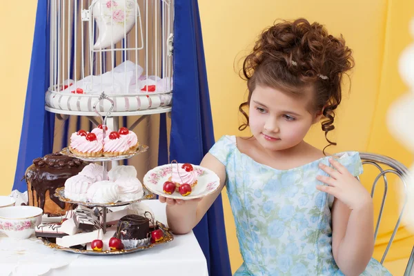 Elegante bambina in posa con piatto di dolci — Foto Stock