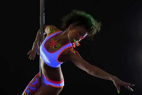 Künstlerische Pole-Tänzerin mit Neon-Muster am Körper — Stockfoto