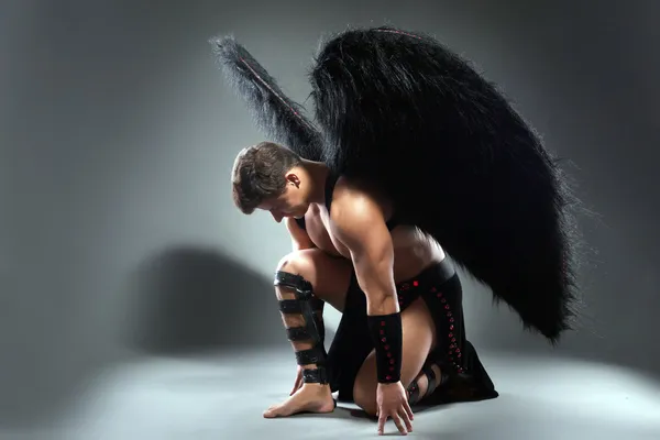 Estúdio tiro de homem bonito posando como anjo caído — Fotografia de Stock