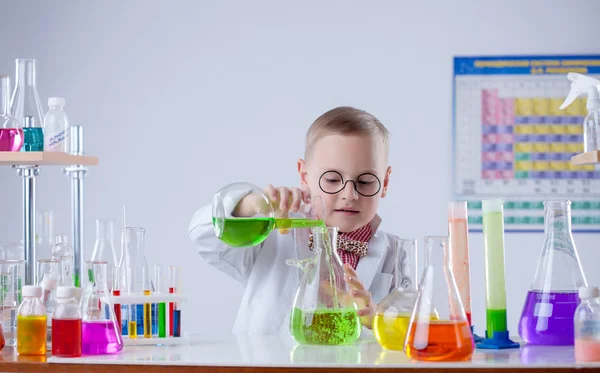 Забавный молодой химик наливает реагент во фляжку — стоковое фото