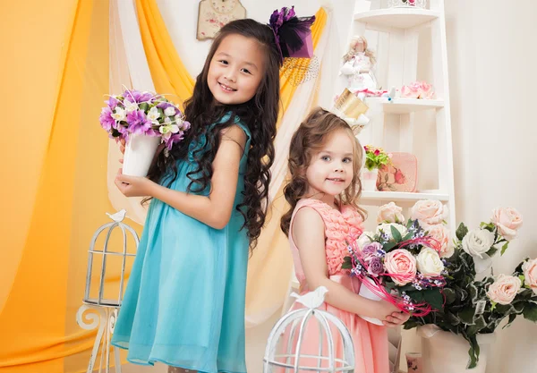 Schattig vriendinnen poseren met boeketten van bloemen — Stockfoto