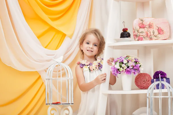 Smiling little girl posing in decorated studio — Stock Photo, Image