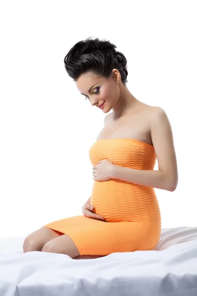 Элегантная беременная женщина позирует в студии — стоковое фото