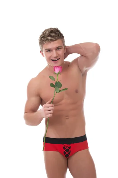 Изображение веселого мускулистого человека, позирующего с розой — стоковое фото