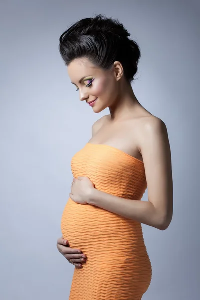 Schöne elegante schwangere Frau posiert im Studio — Stockfoto