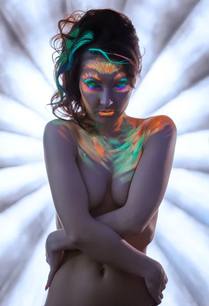 Nackte junge Frau posiert mit leuchtendem Neon-Make-up — Stockfoto