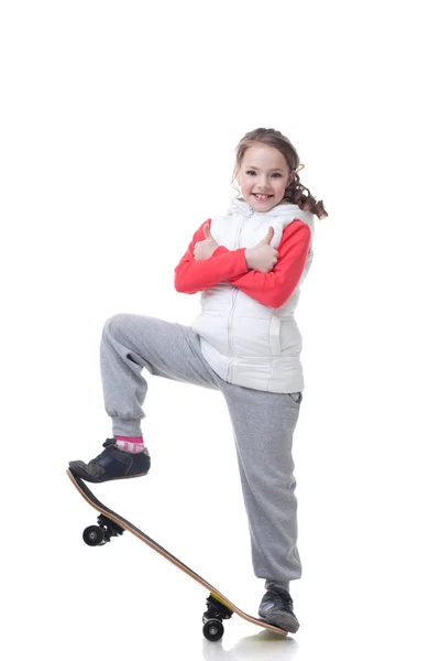 Joyeux petit skateboarder posant avec les pouces levés — Photo