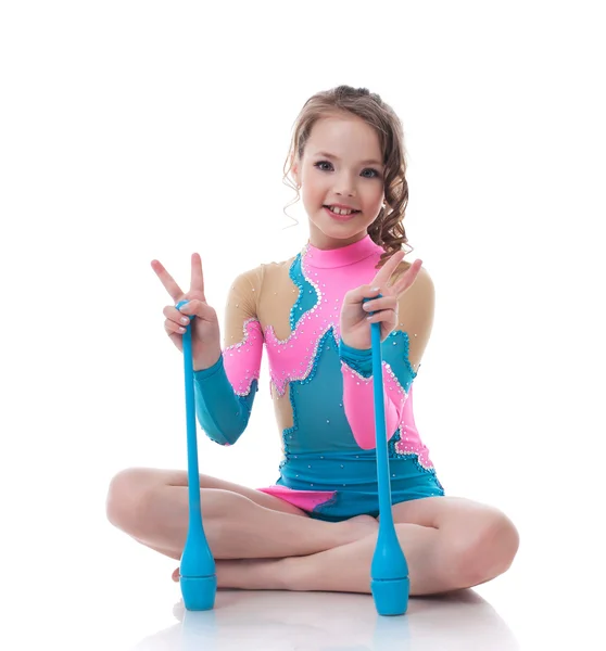Glad liten gymnast poserar med muskotblomma — Stockfoto