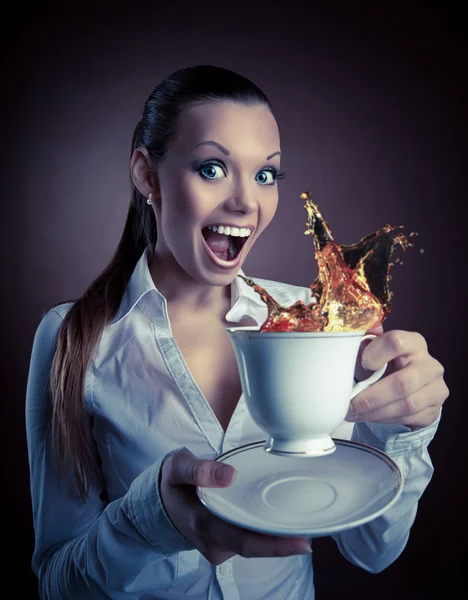 搞笑女人与杯和飞溅的茶的微笑 — 图库照片