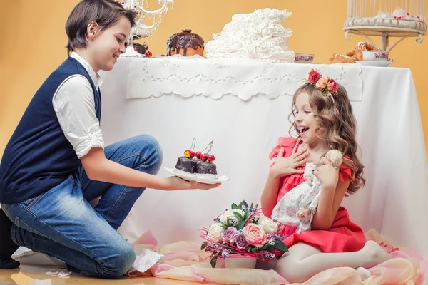 陽気なかわいい少年のイメージは姉妹を扱うお菓子 — ストック写真