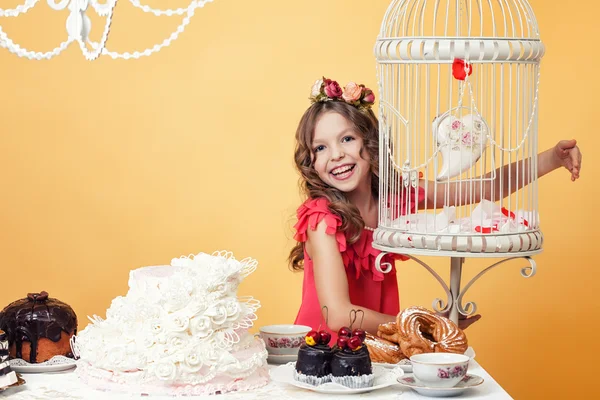 Chica feliz posando con dulces en el interior de la vendimia — Foto de Stock