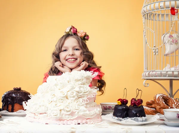 お菓子をいっぱいでポーズ幸せな笑顔の女の子 — ストック写真
