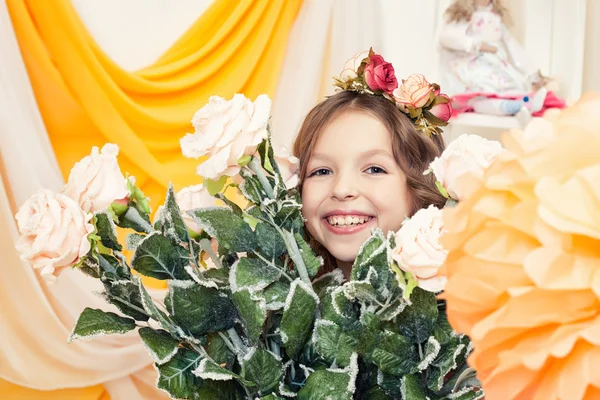 Glückliches kleines Mädchen posiert mit großem Rosenstrauß — Stockfoto