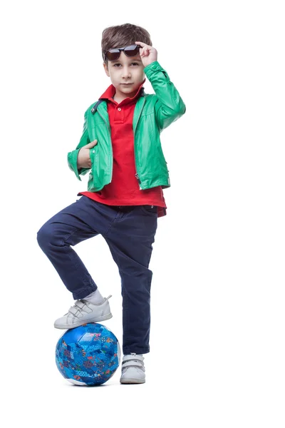 Спортивный симпатичный мальчик позирует с мячом в студии — стоковое фото