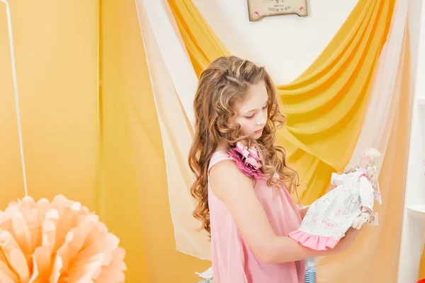 Little girl playing with doll in retro interior — Stock Photo, Image