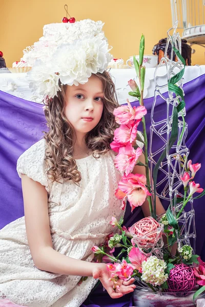 Sevimli küçük kız çiçek aranjmanları ile poz — Stok fotoğraf