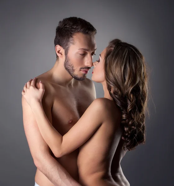 Apaixonados amantes nus abraçando no estúdio — Fotografia de Stock