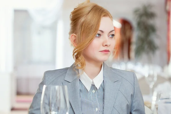 Chica joven confiada posando en la mesa en el restaurante —  Fotos de Stock